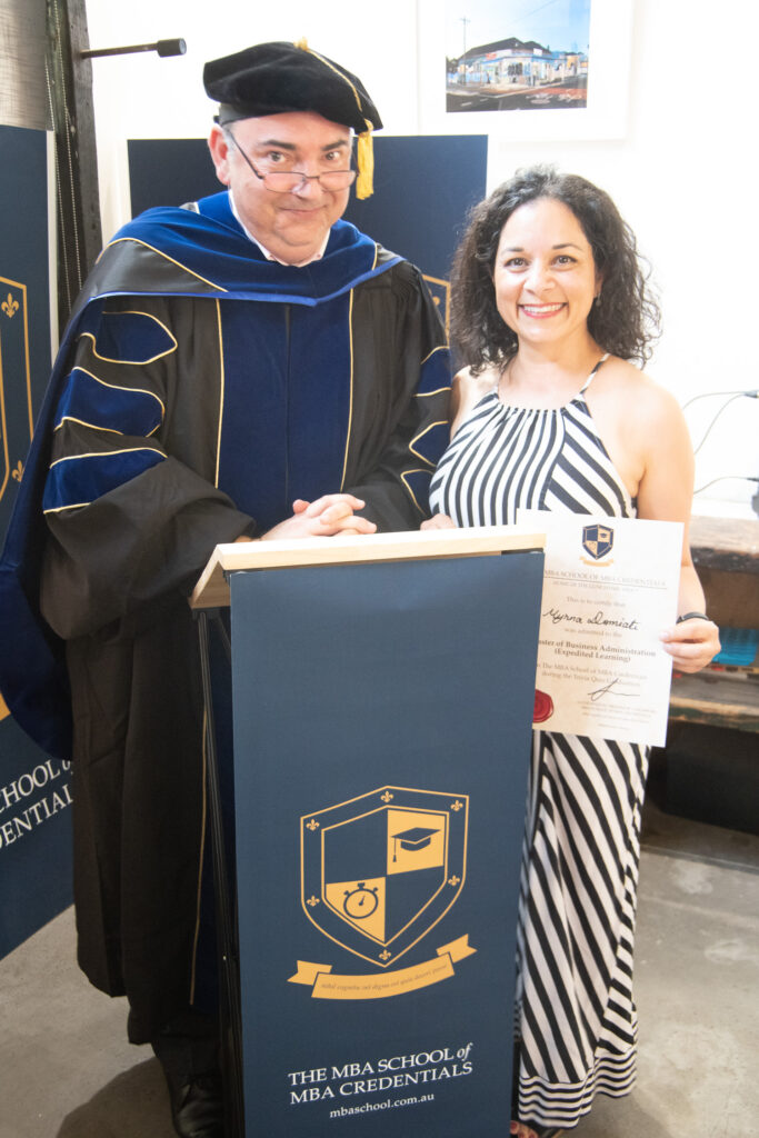 Myrna Domiati, receiving her MBA from Professor Longsword of The MBA School Of MBA Credentials