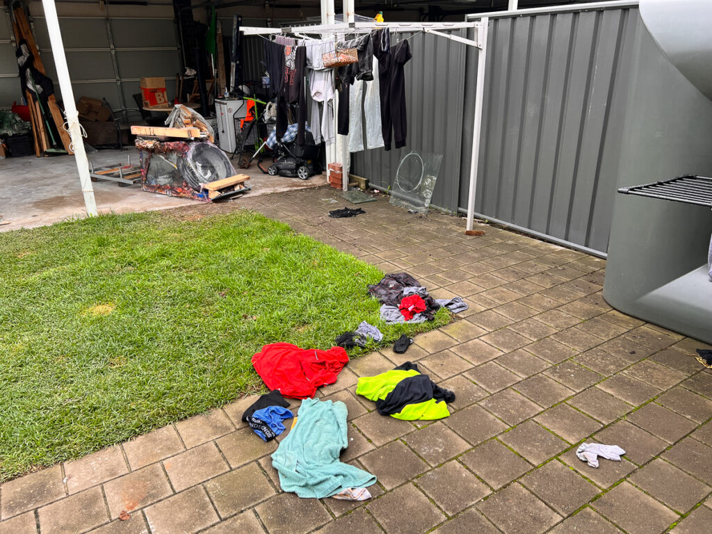 Mitch Vahldieck, three-week old washing laying on the grass and paving. It seems he was not interested in picking it up, and by this point all communication between us had broken down. 2023. 