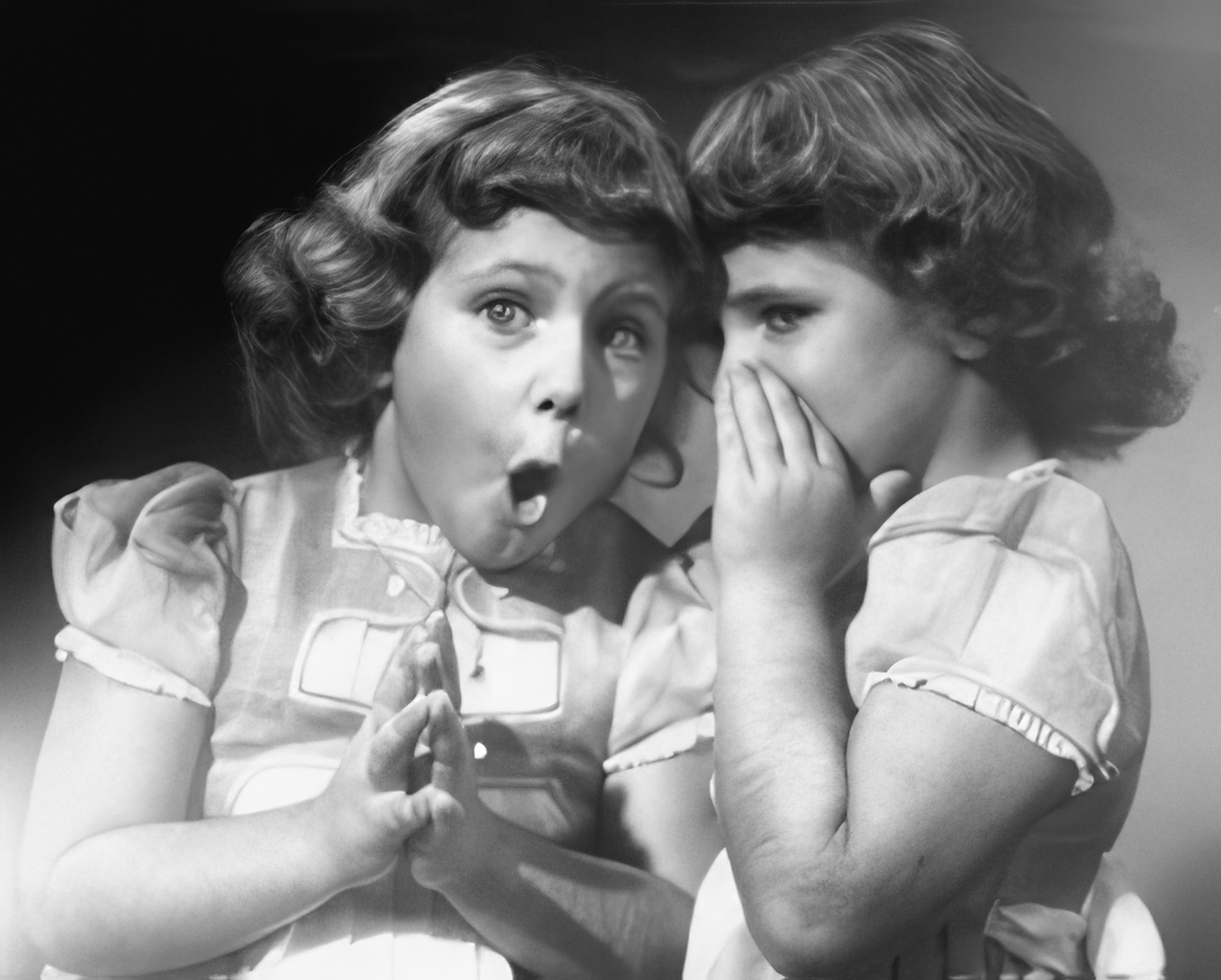 Two young girls sharing secrets or gossip